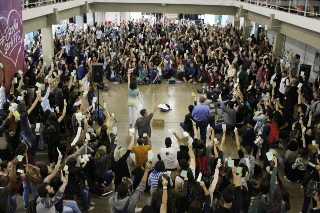Estudantes levantam suas fichas de votação para aprovarem proposta de destituição do novo reitor nomeado da UFFS, Marcelo Recktenvald.